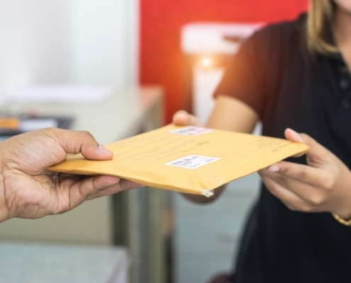 Image of a person handing postage to a mail person.