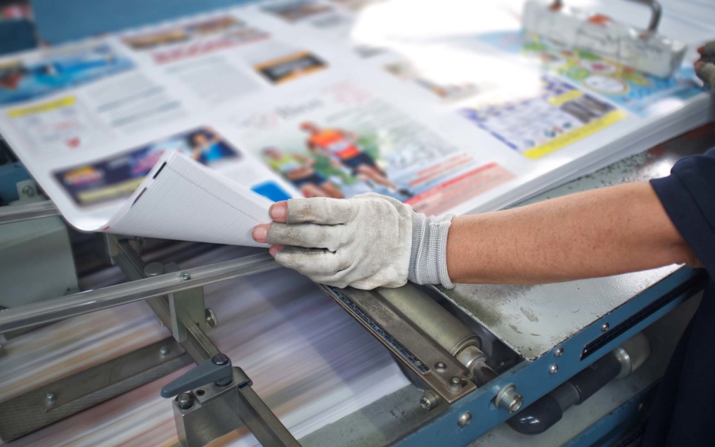 View of a print worker looking over large format prints